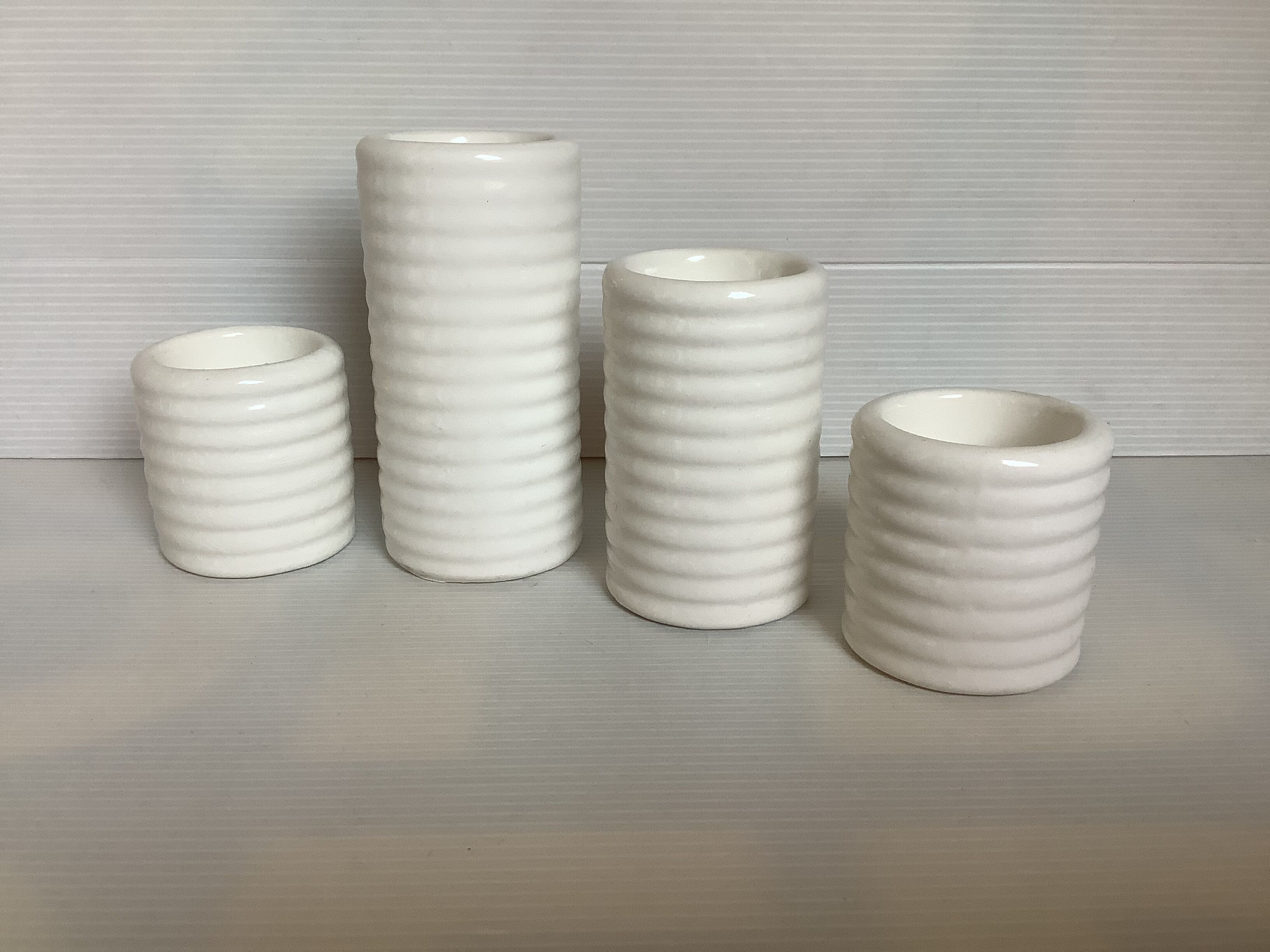 Four white earthenware candle holders