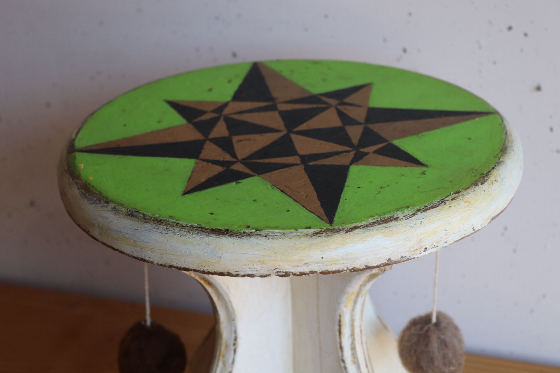 Small wooden stool painted with a star design.