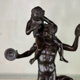 Dionysus on the shoulders of a satyr, bronze after the antique on a yellow Siena base.