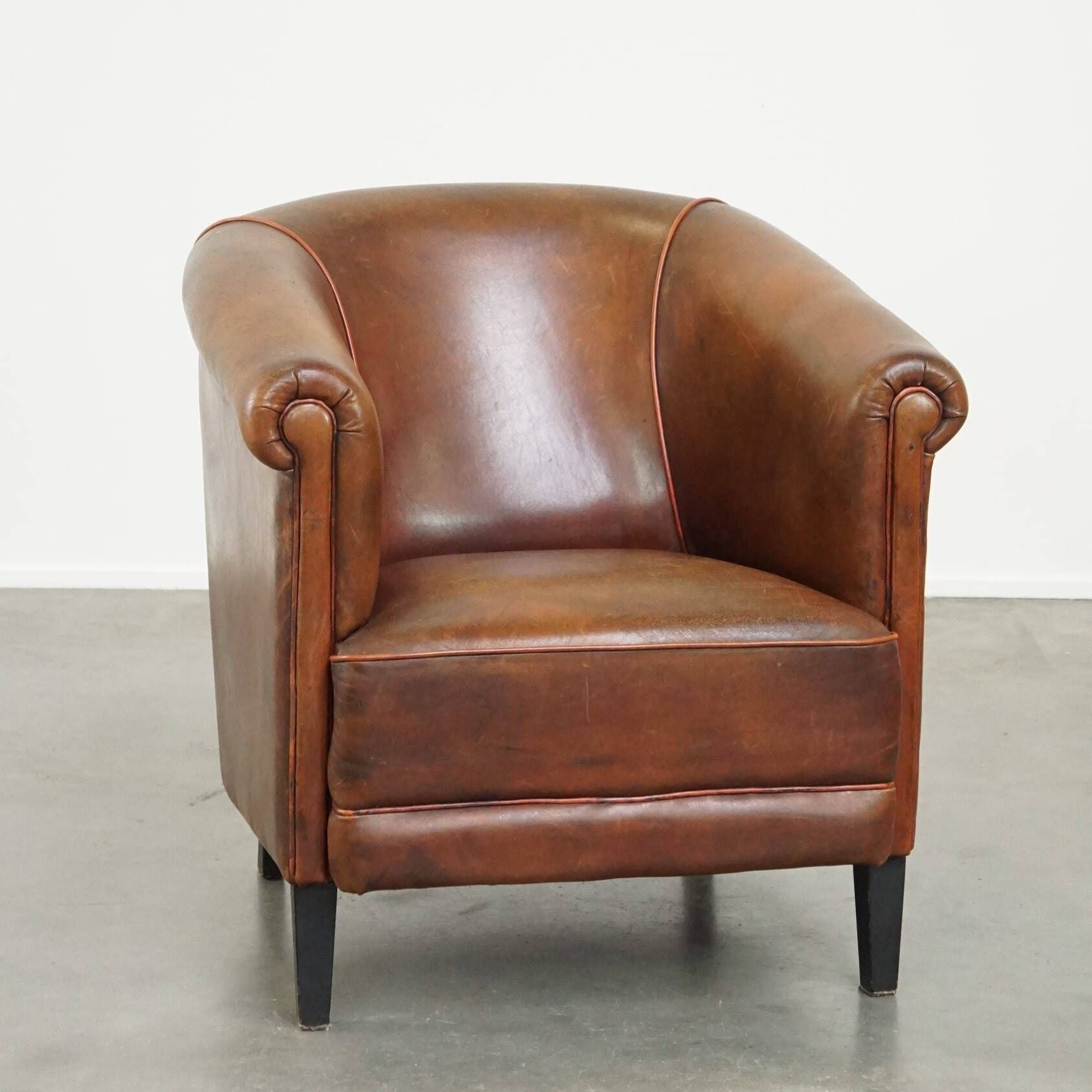Neat, elegantly finished, cozy sheepskin club armchair with a fixed seat cushion