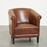 Neat, elegantly finished, cozy sheepskin club armchair with a fixed seat cushion