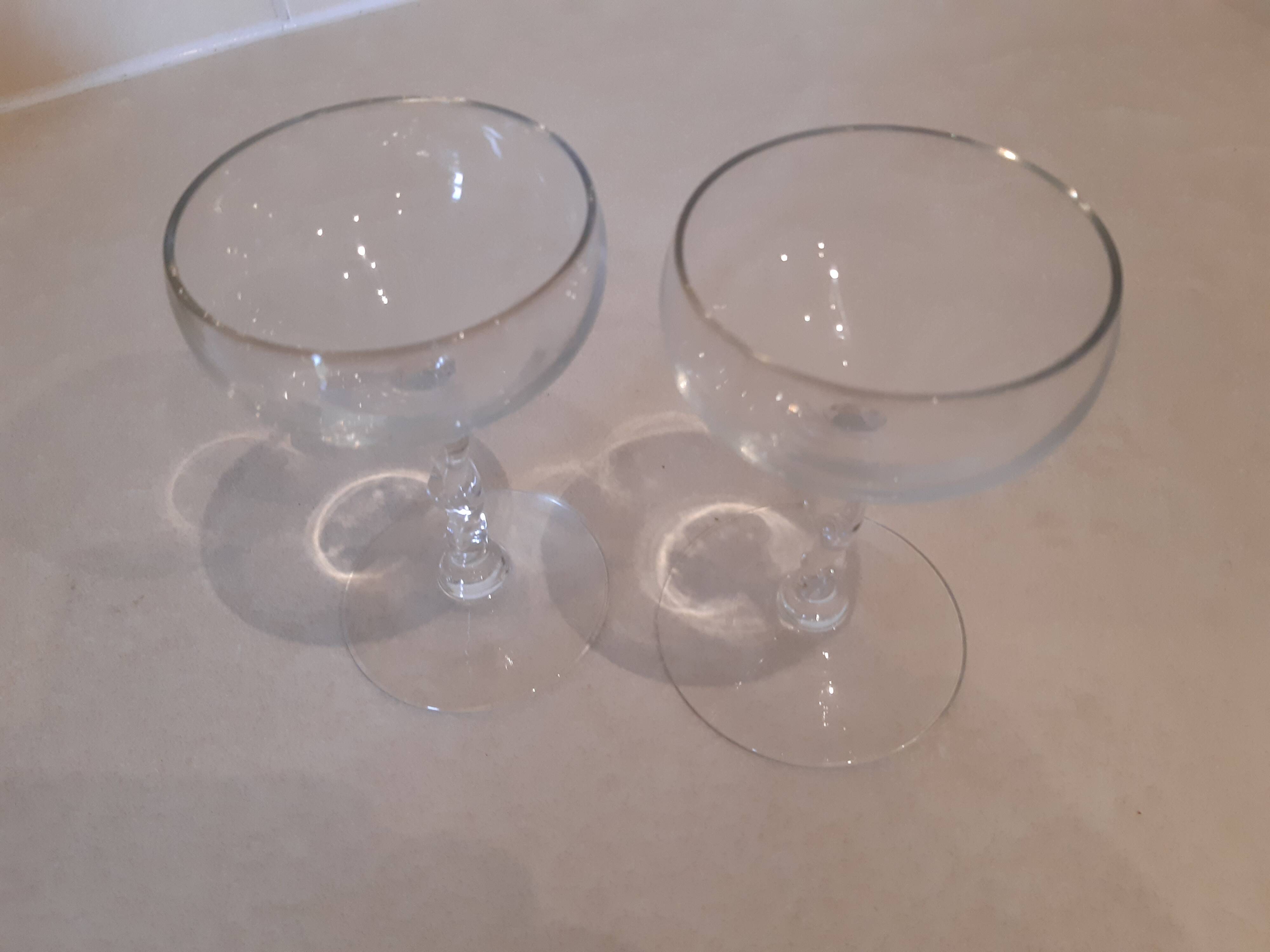 Two small crystal champagne glasses with twisted stems.