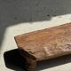 Small stool, footrest in blond teak, organic monoxyle with cut corners.