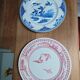 A pair of old flat plates with red and blue bird patterns.