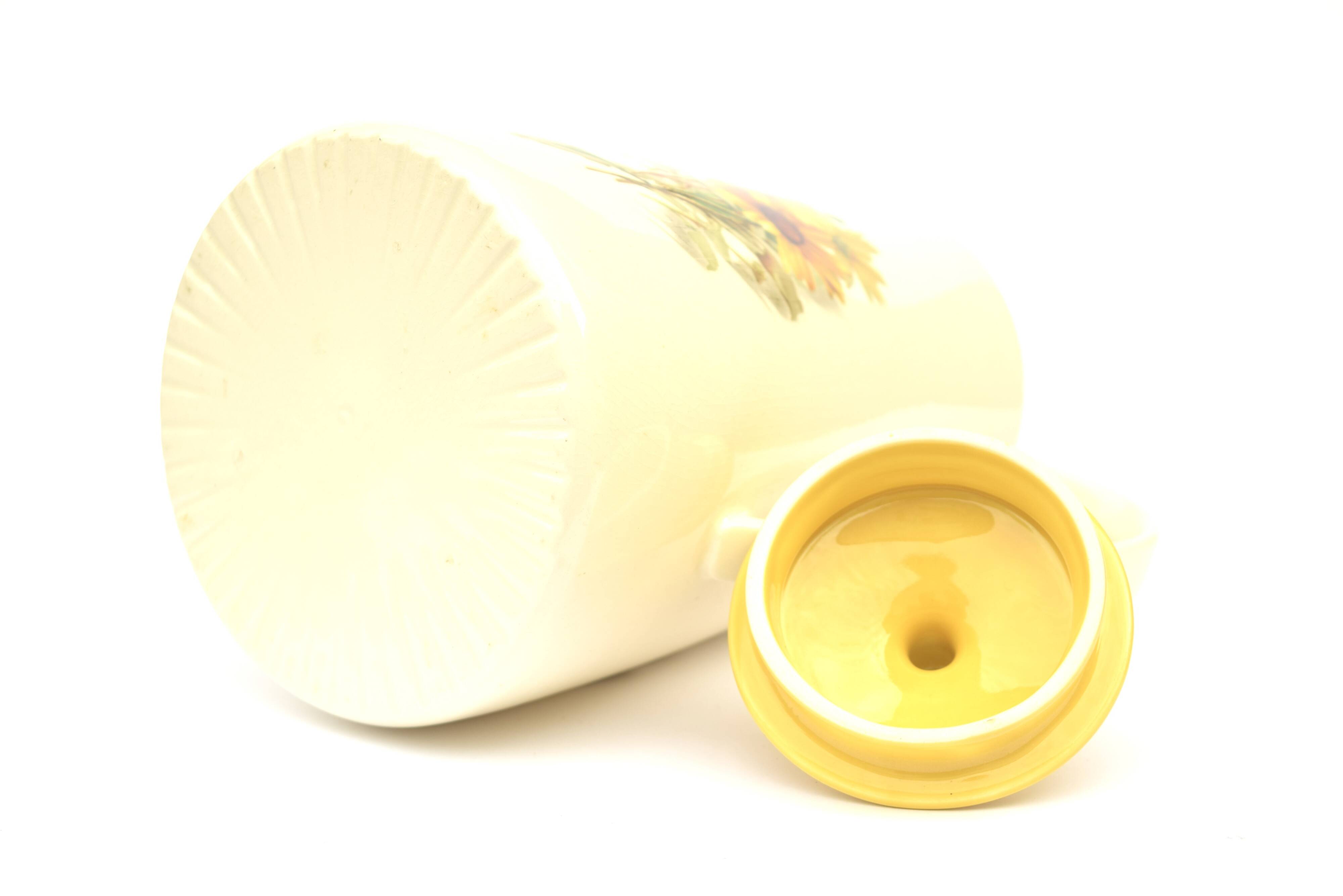 Old glazed ceramic coffee pot decorated with sunflowers