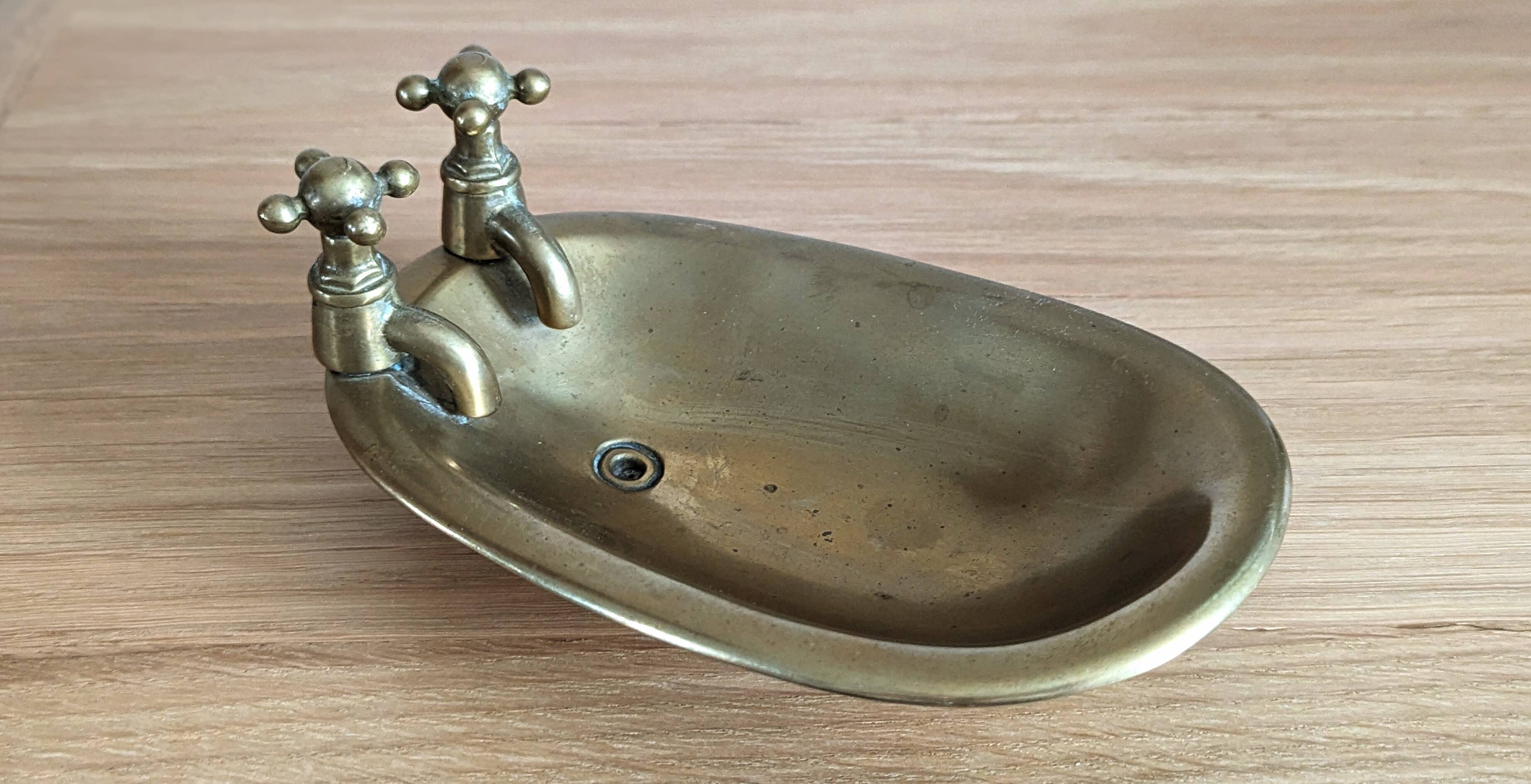 Old soap dish in the shape of a brass bathtub