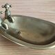 Old soap dish in the shape of a brass bathtub