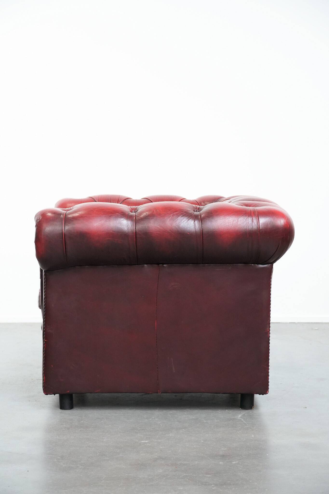 Red English cowhide Chesterfield armchair finished with decorative nails
