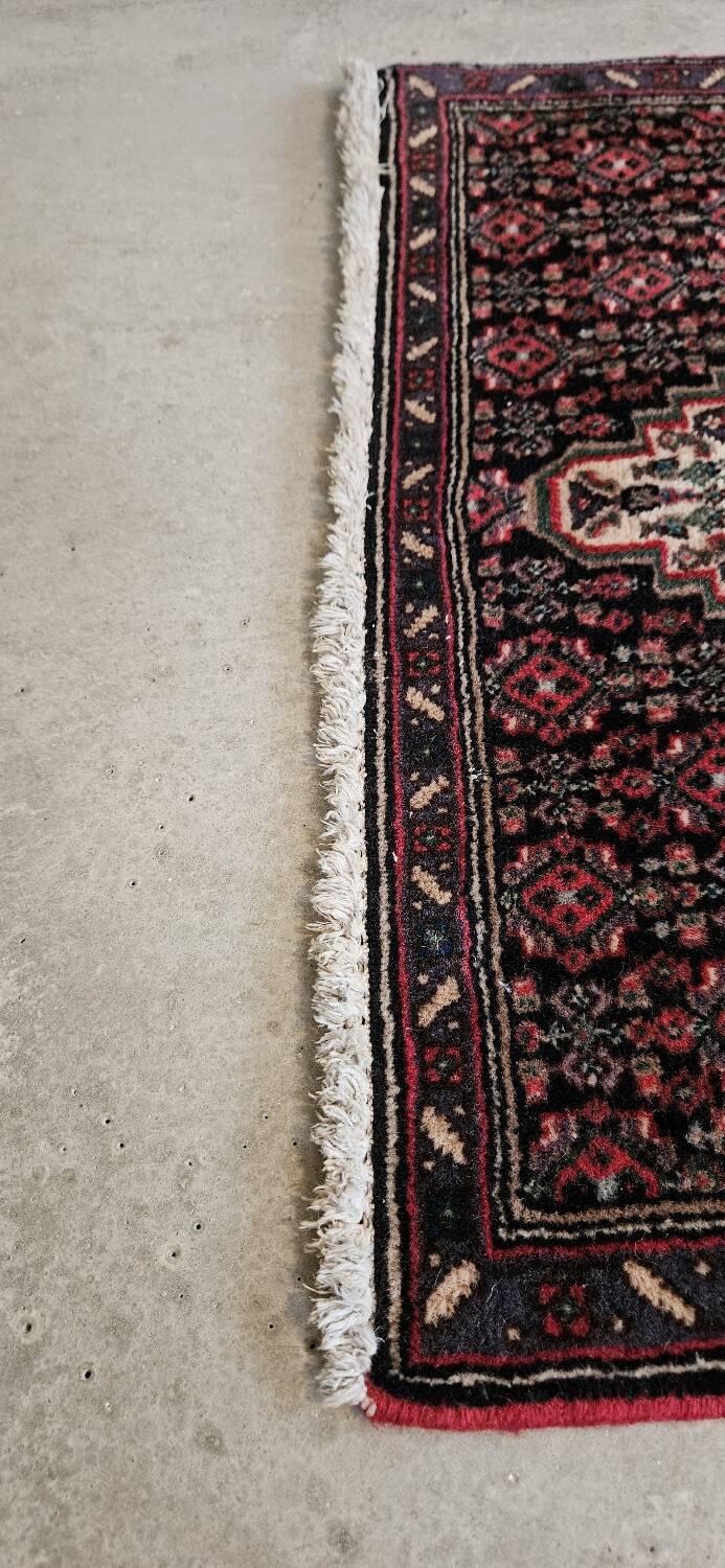 Ancient Persian carpet, wool, red tones, hand-knotted.