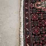 Ancient Persian carpet, wool, red tones, hand-knotted.