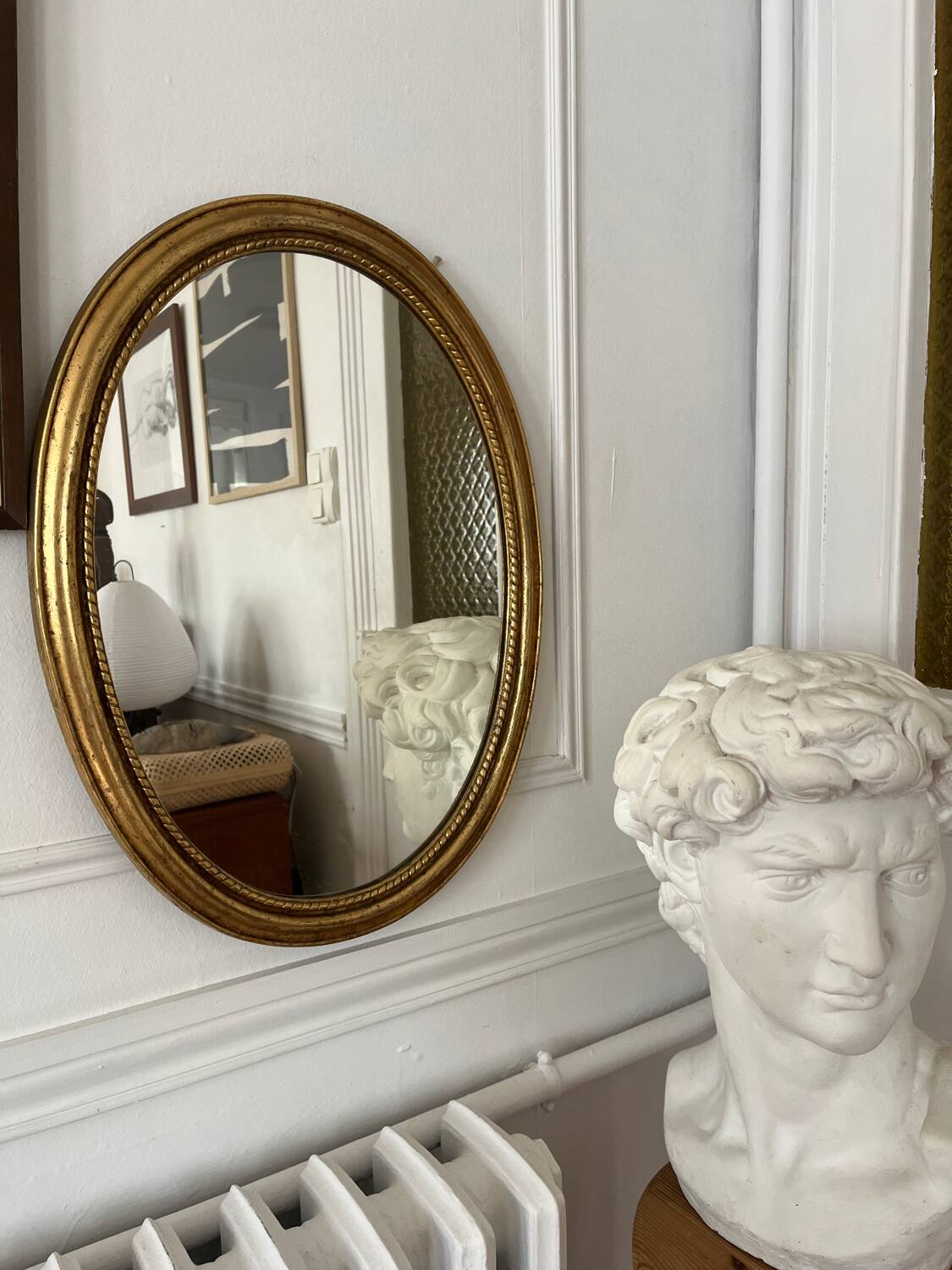 Oval mirror in antique gilded wood
