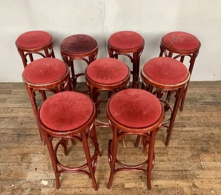 Series of 9 bistro bar stools in curved wooden restaurant sitting red fabric