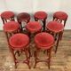Series of 9 bistro bar stools in curved wooden restaurant sitting red fabric