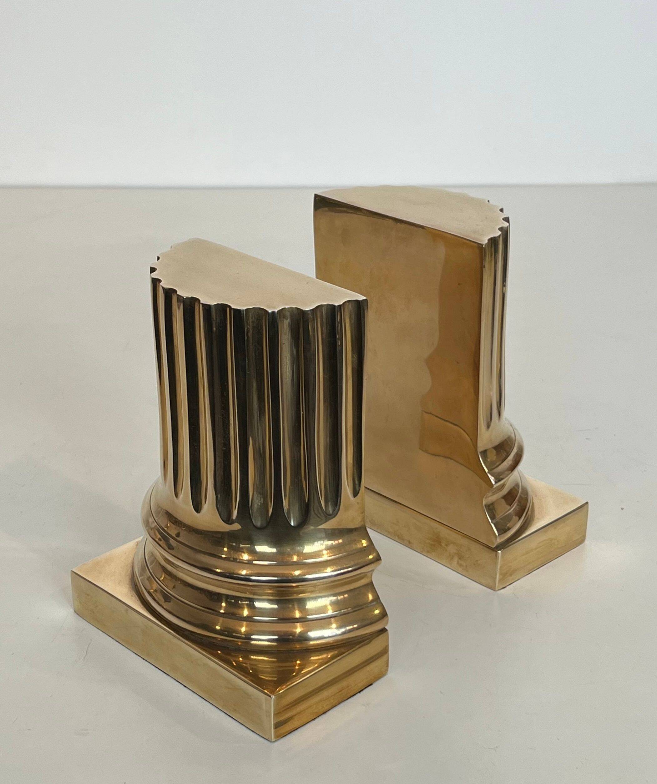 A pair of brass bookends representing columns.