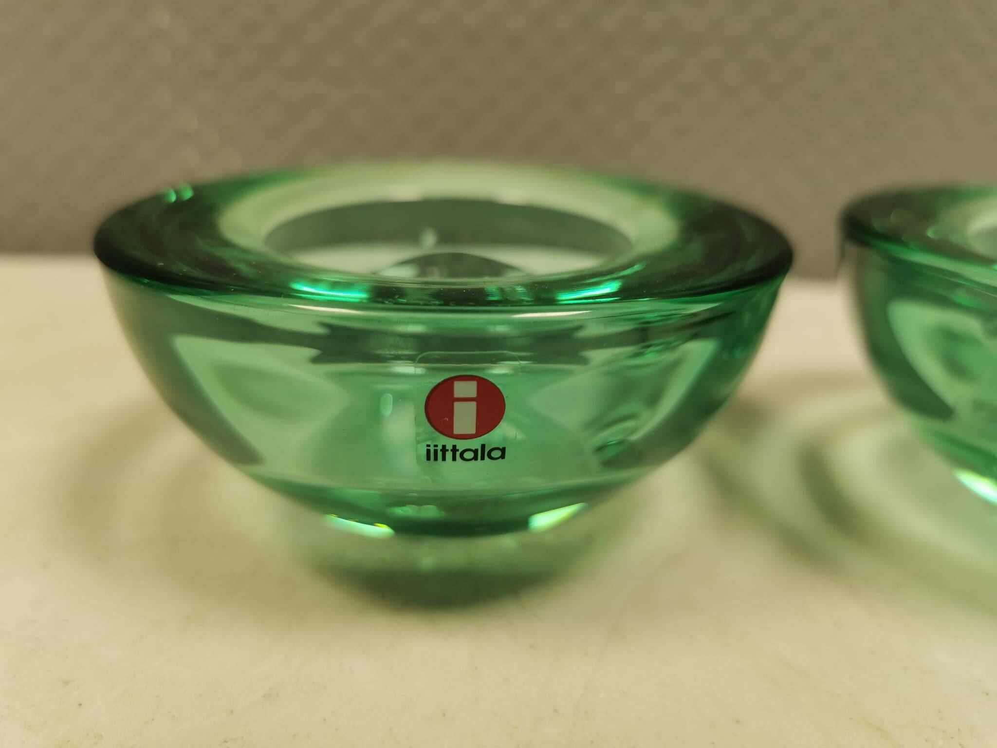 A set of iitalla candle holders in green transparent glass.