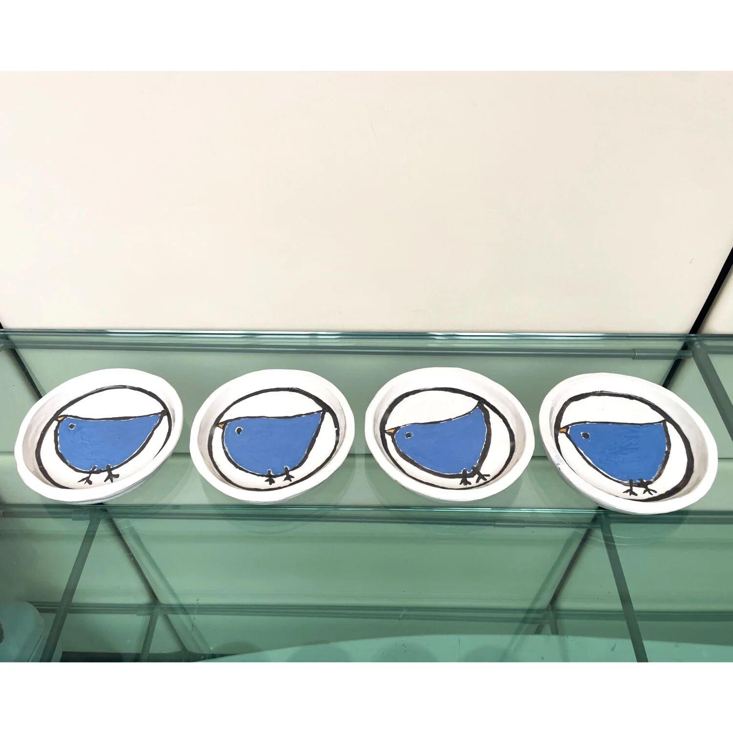 Handmade white ceramic plates with a blue bird in folk art style, set of 4.