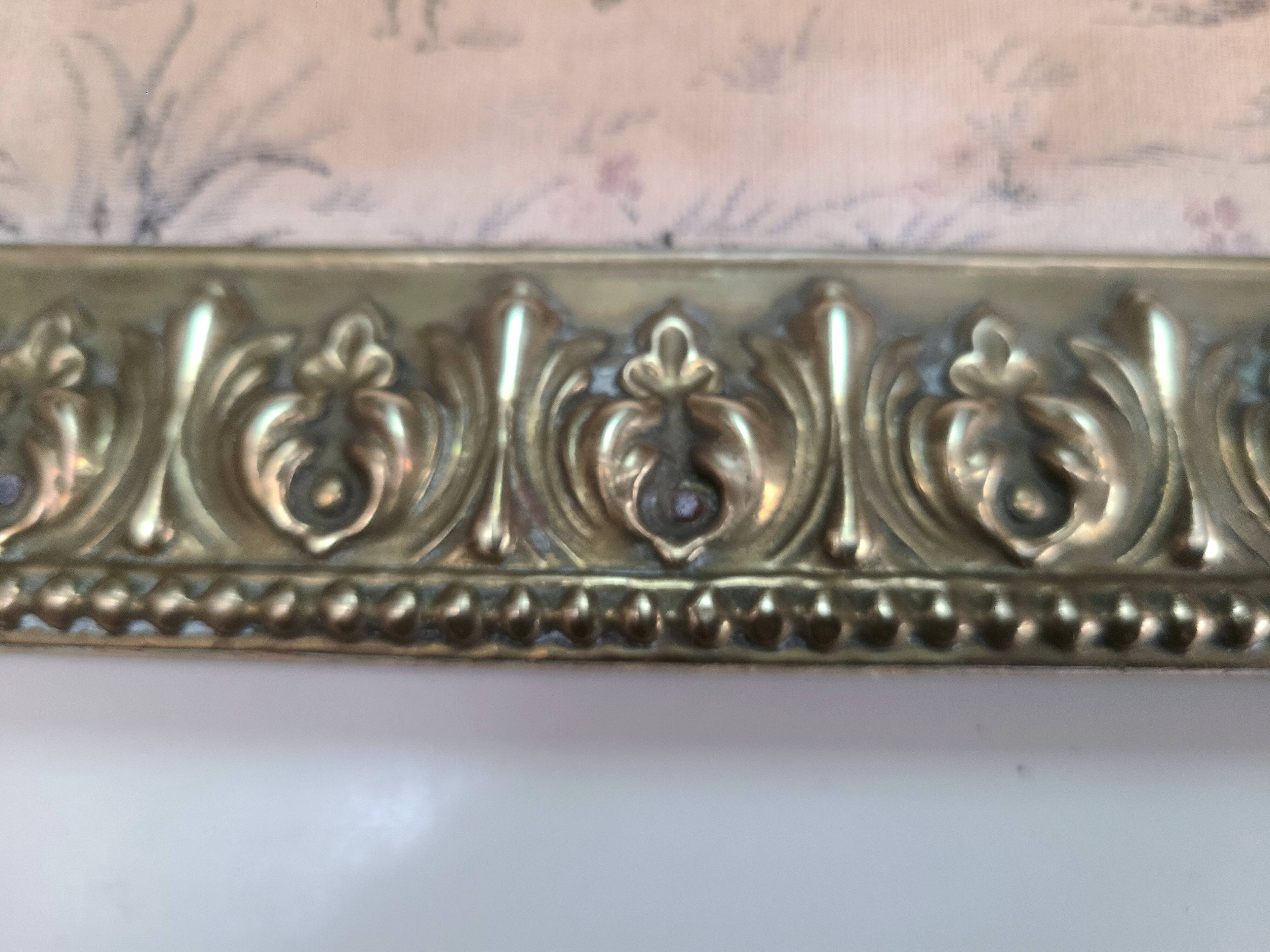 Antique tapestries framed in repoussé brass.