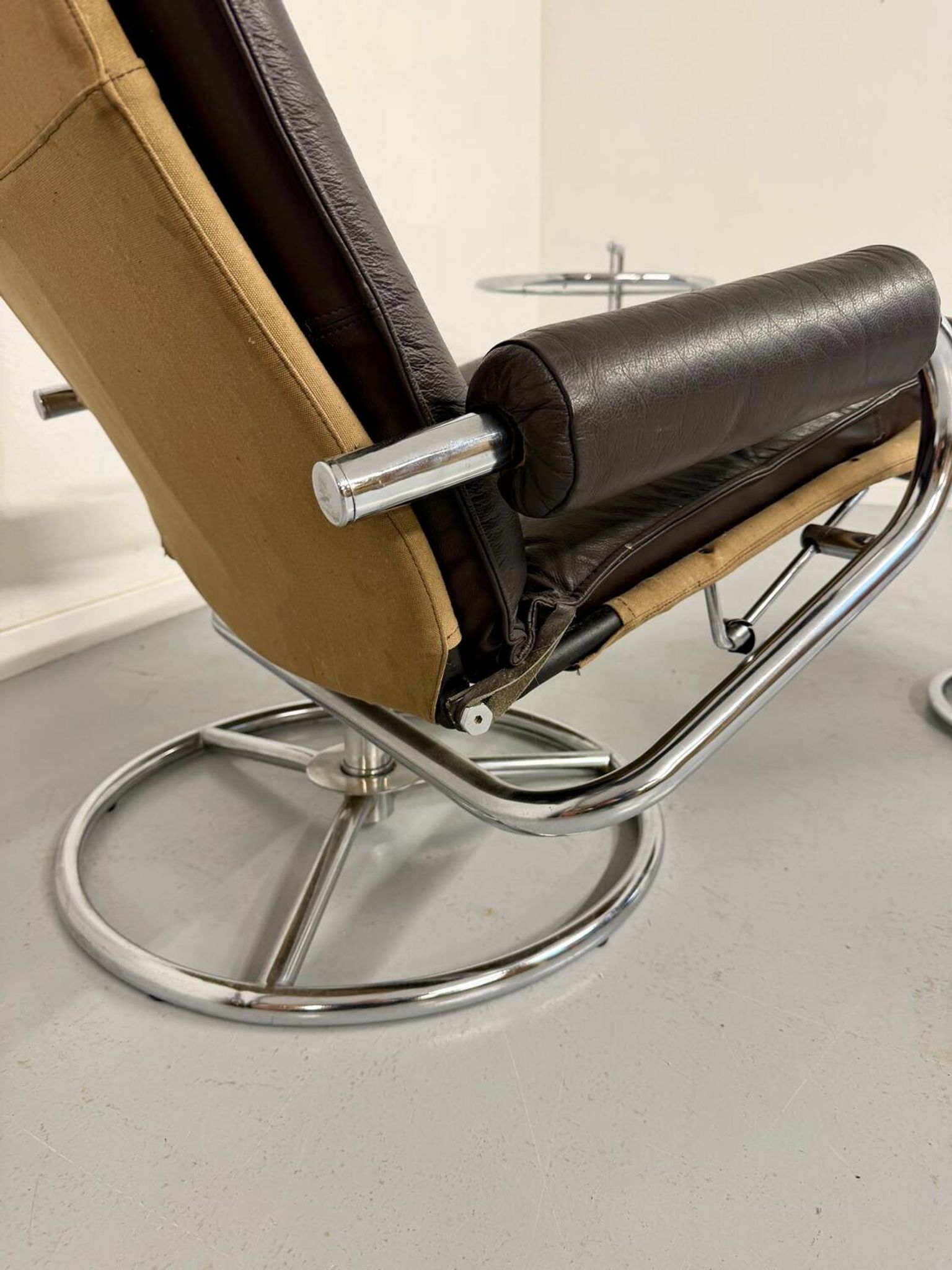 Vintage leather reclining armchair and its 1970s designer ottoman.