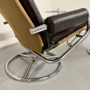 Vintage leather reclining armchair and its 1970s designer ottoman.