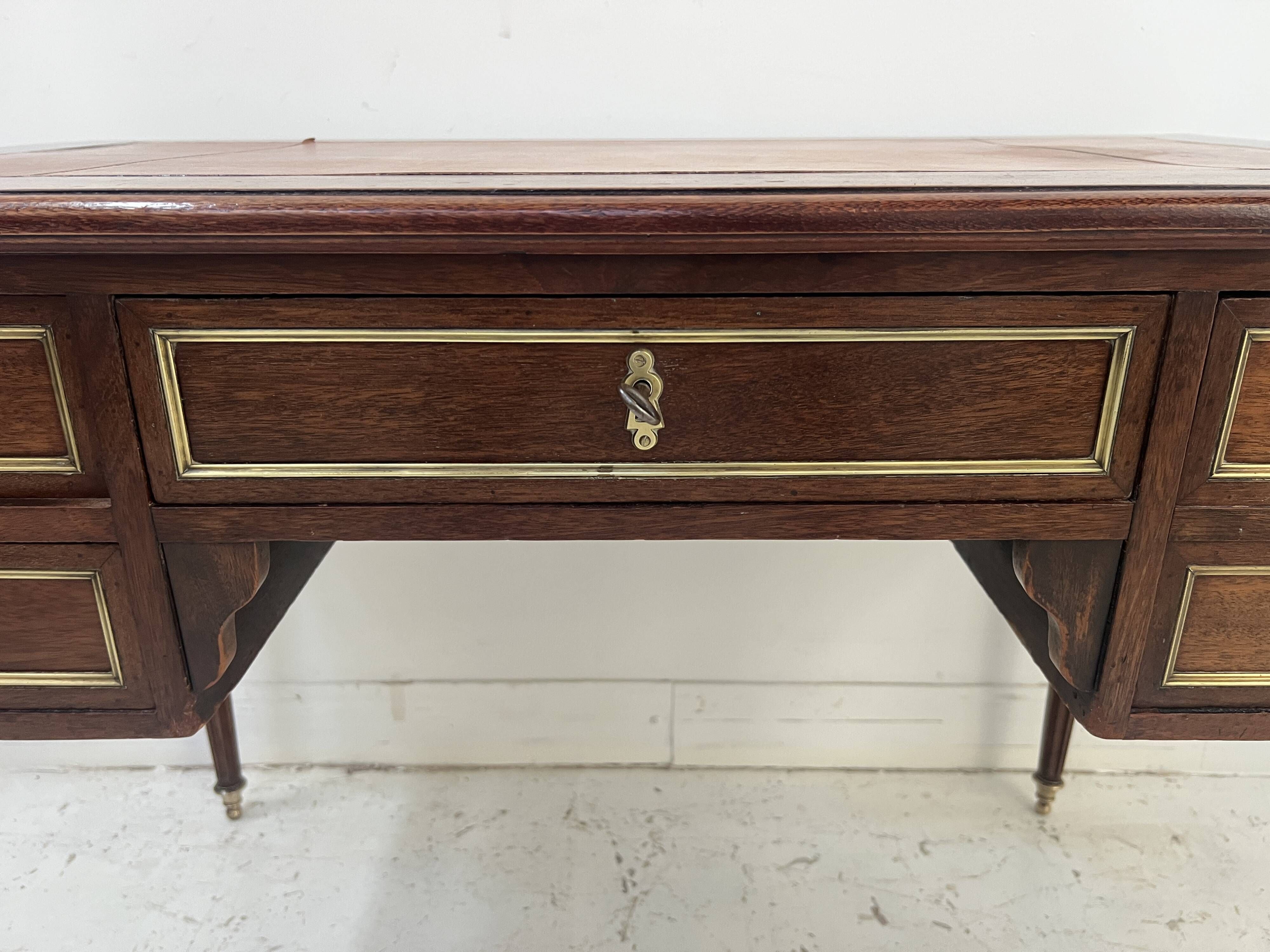 Louis XVI style desk in mahogany and mahogany veneer, 20th century.