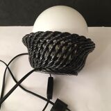 Table lamp with black porcelain support in the shape of a woven basket and opaque glass ball globe