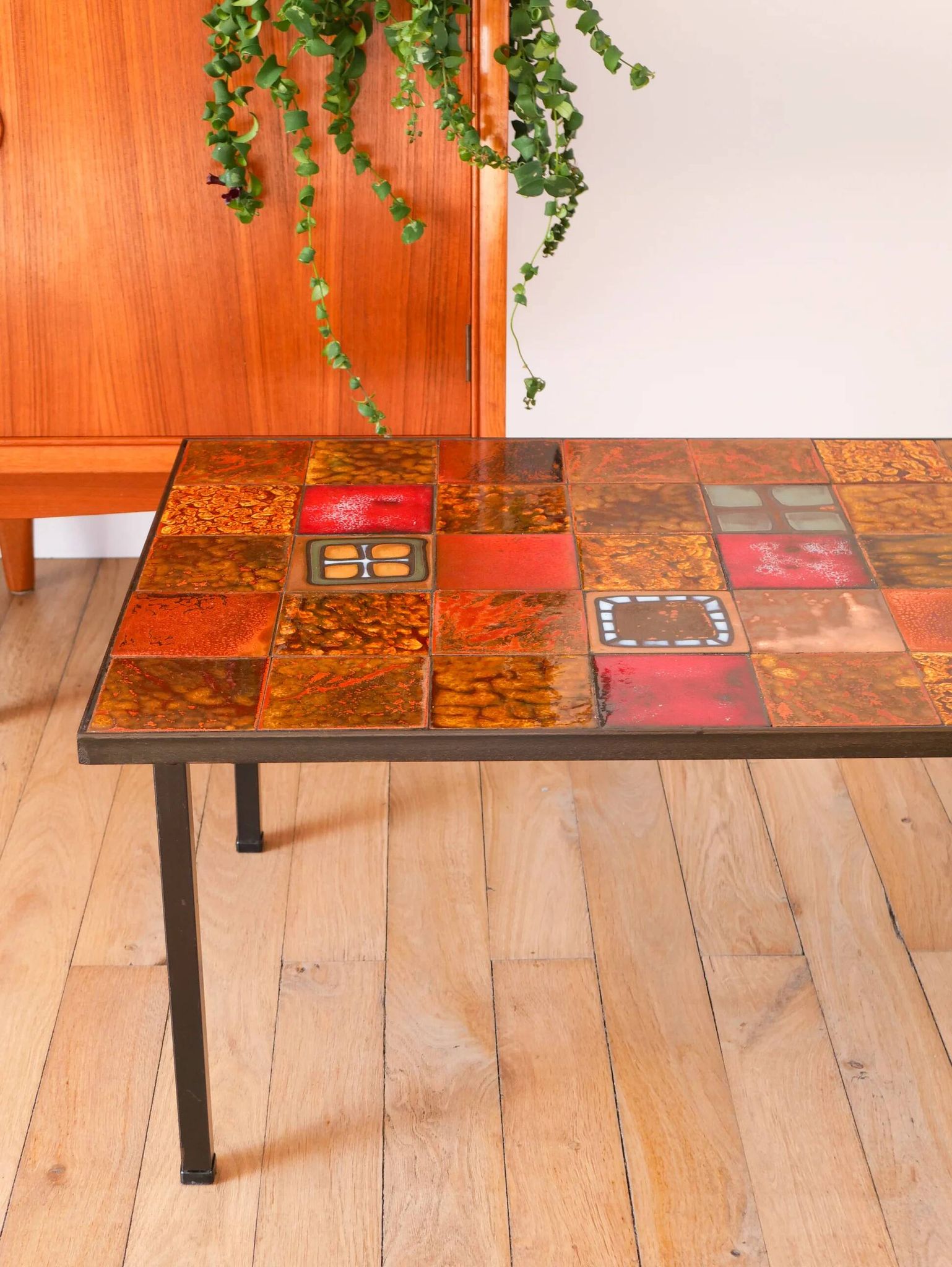Ceramic and black iron coffee table, attributed to the Roche-Bobois brand, with a black metal base and structure, rectangular ceramic top from Vallauris with colourful patterns in ochre and orange, design from the 1970s.