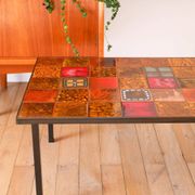 Ceramic and black iron coffee table, attributed to the Roche-Bobois brand, with a black metal base and structure, rectangular ceramic top from Vallauris with colourful patterns in ochre and orange, design from the 1970s.