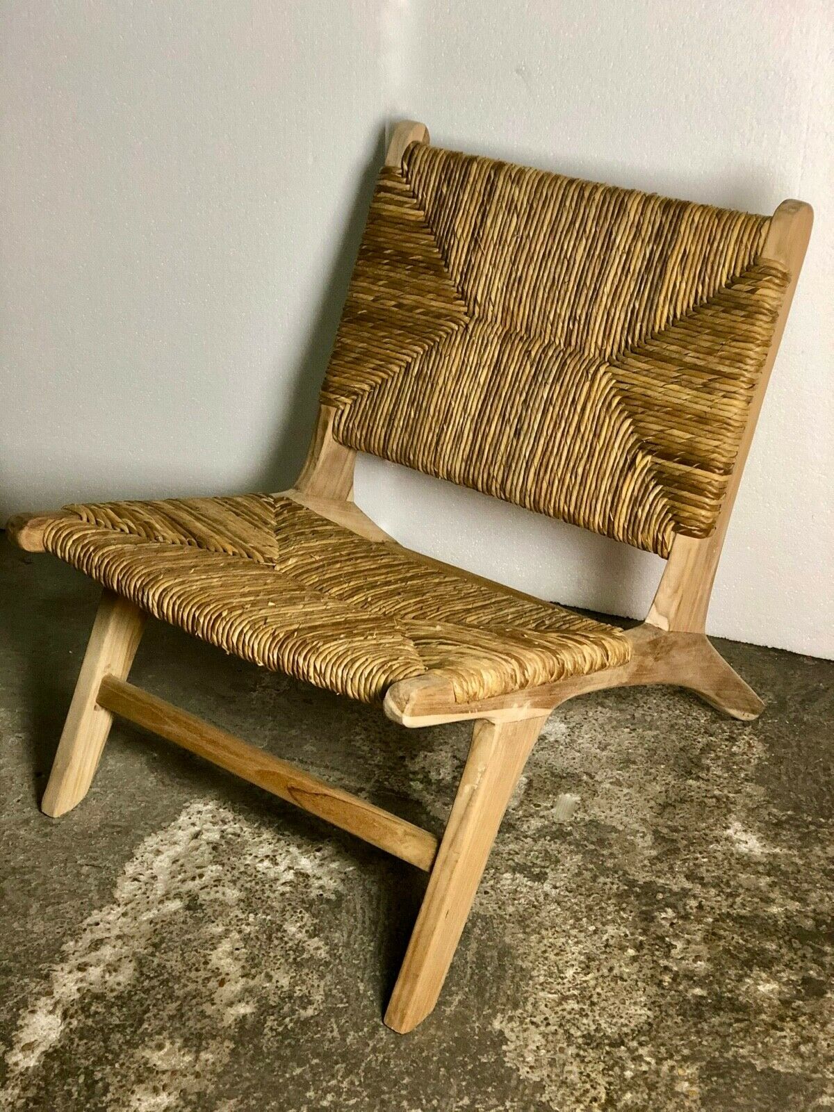 Low armchair in raw teak with seat and mulched backrest