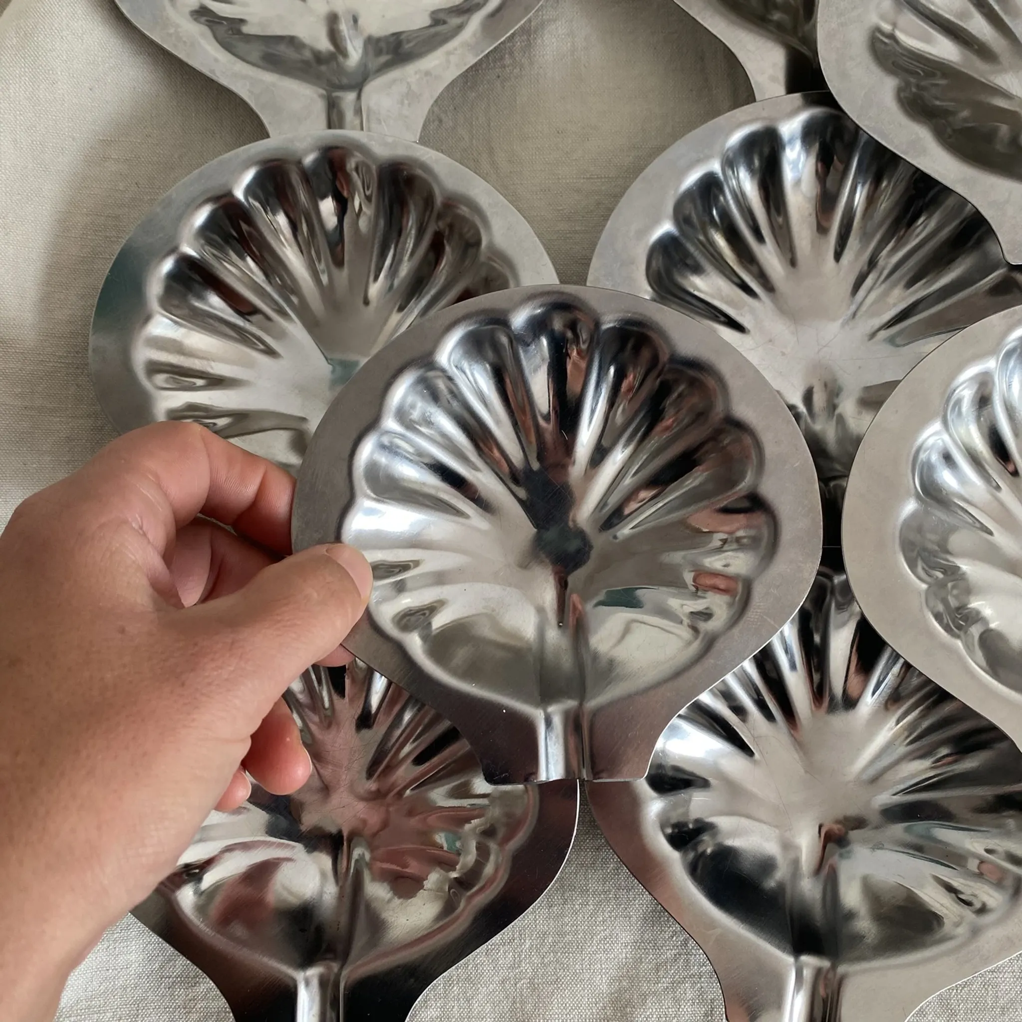 Set of 12 stainless steel scallop shells, 1970s-80s.