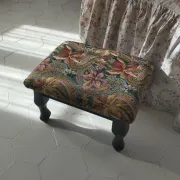 Petit ottoman repose-pied tapisserie vintage.