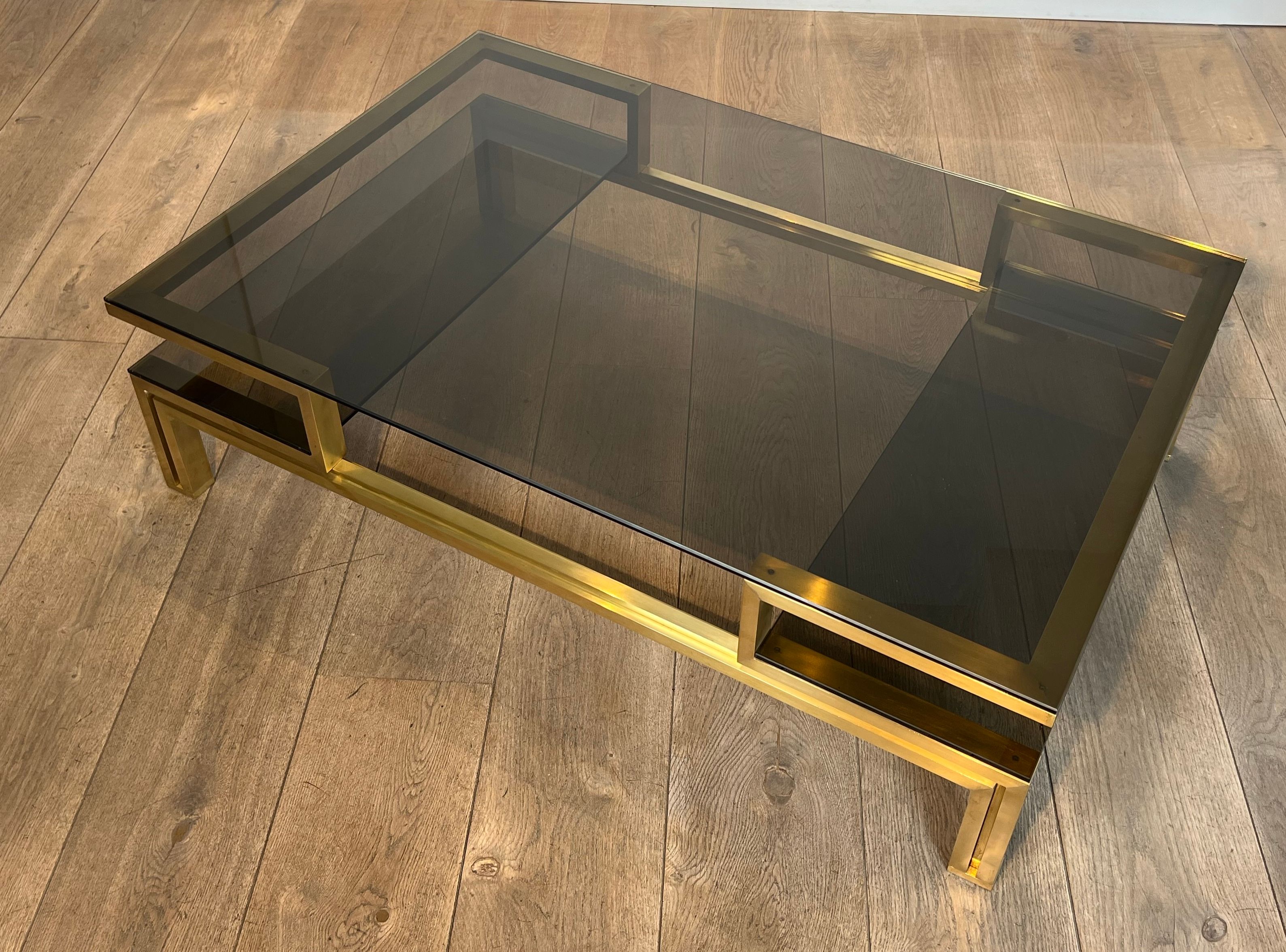 Modernist coffee table in brass and smoked glass tops by Guy Lefèvre for Maison Jansen.