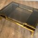 Modernist coffee table in brass and smoked glass tops by Guy Lefèvre for Maison Jansen.