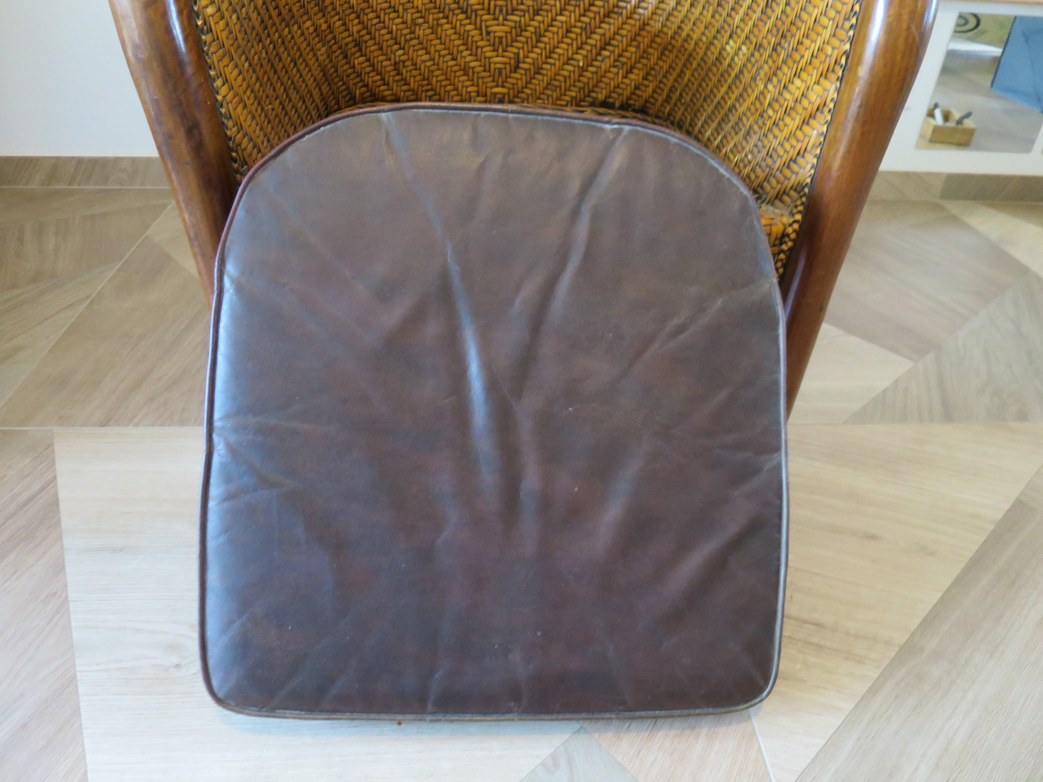 Colonial style armchair in woven rattan and exotic wood