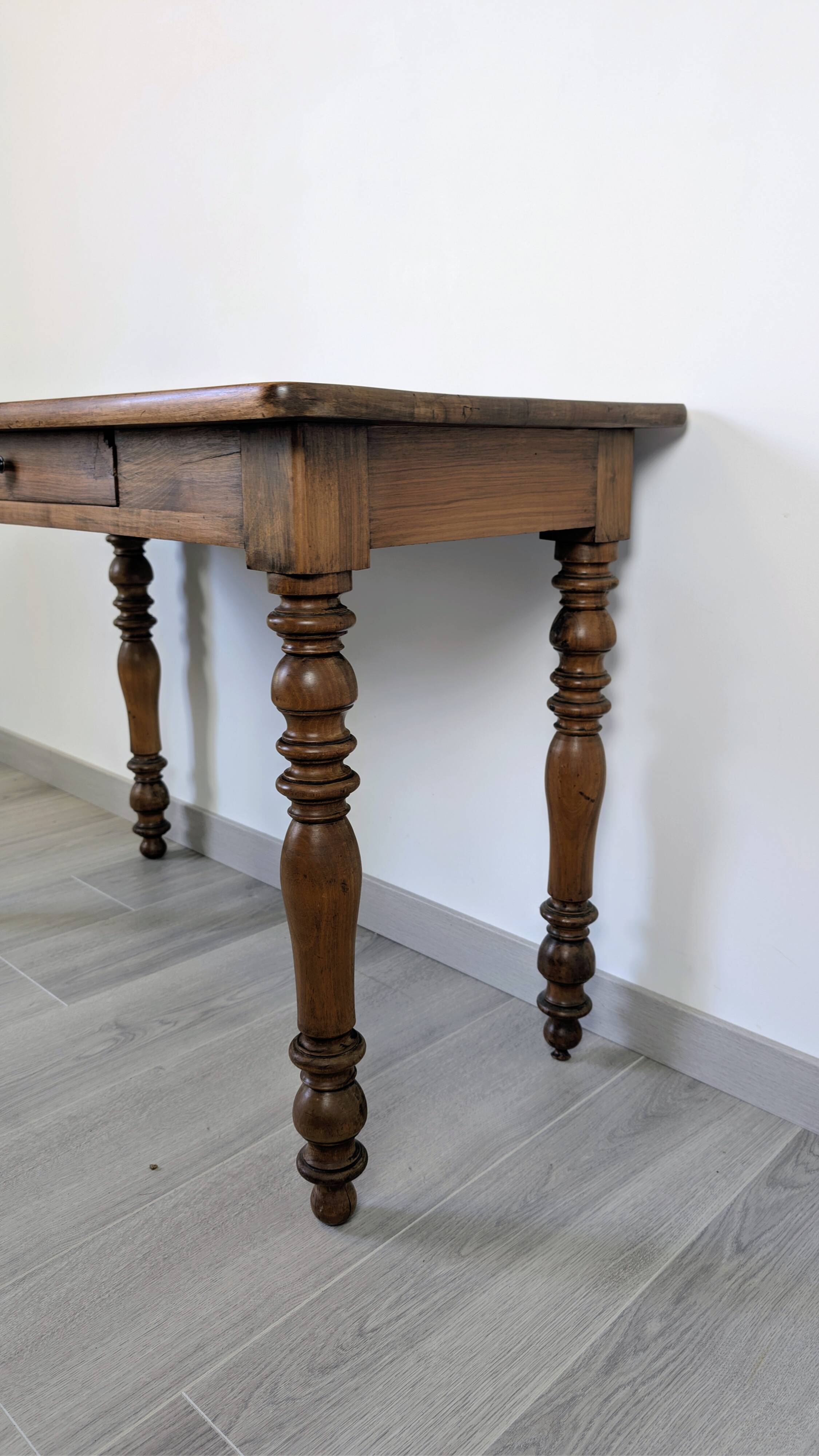 Antique writing table in the Napoleon III style with turned wooden legs.