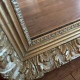 Antique mirror with a wooden and gilded stucco frame.