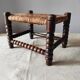 Antique wooden turned spool footrest with straw.
