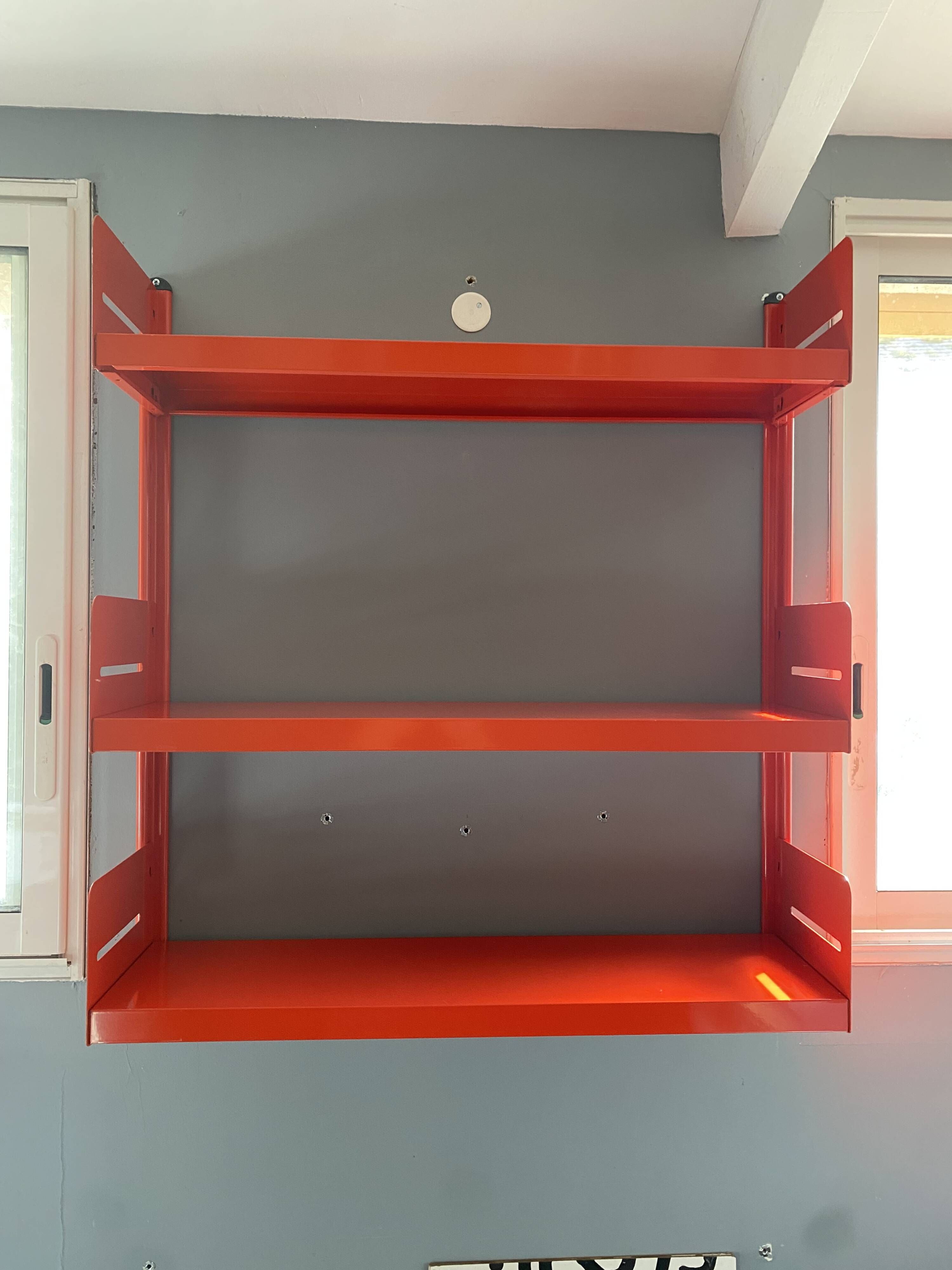 Modular red metal wall shelf in Congresso Lips Vago style.