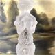 Tall molded glass candle holder with ram heads
