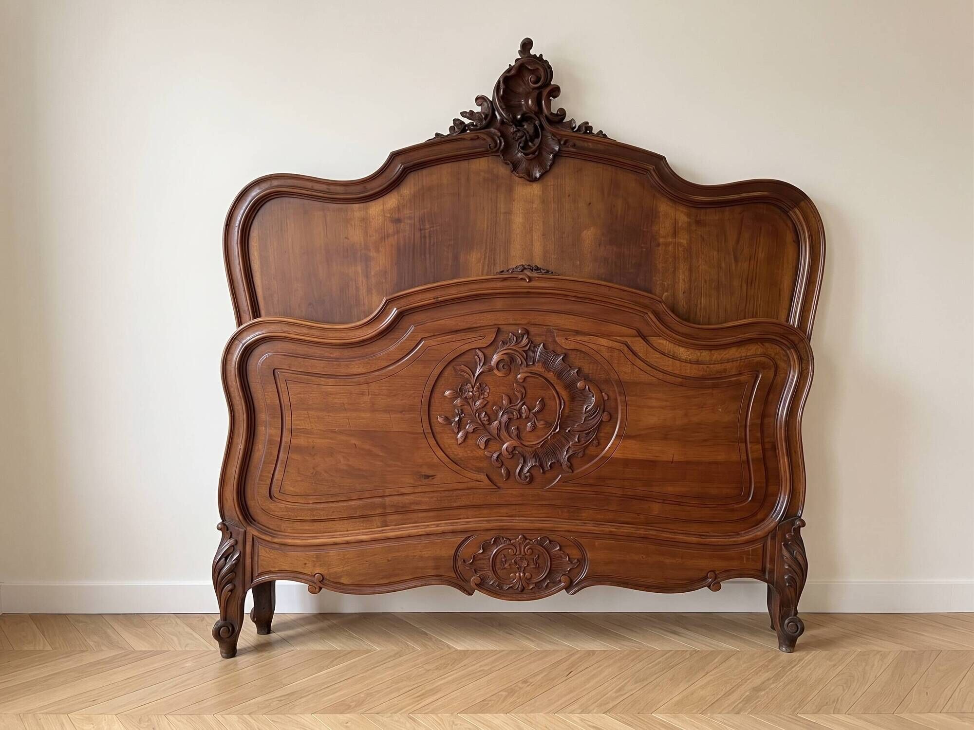 Antique carved bed in Louis XV style made of wood.