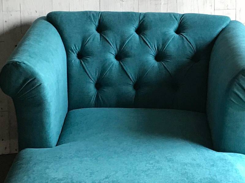 Mid-century turquoise blue fabric sofa with solid oak legs and tufting.