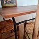 Table with tubular metal legs and wooden top.