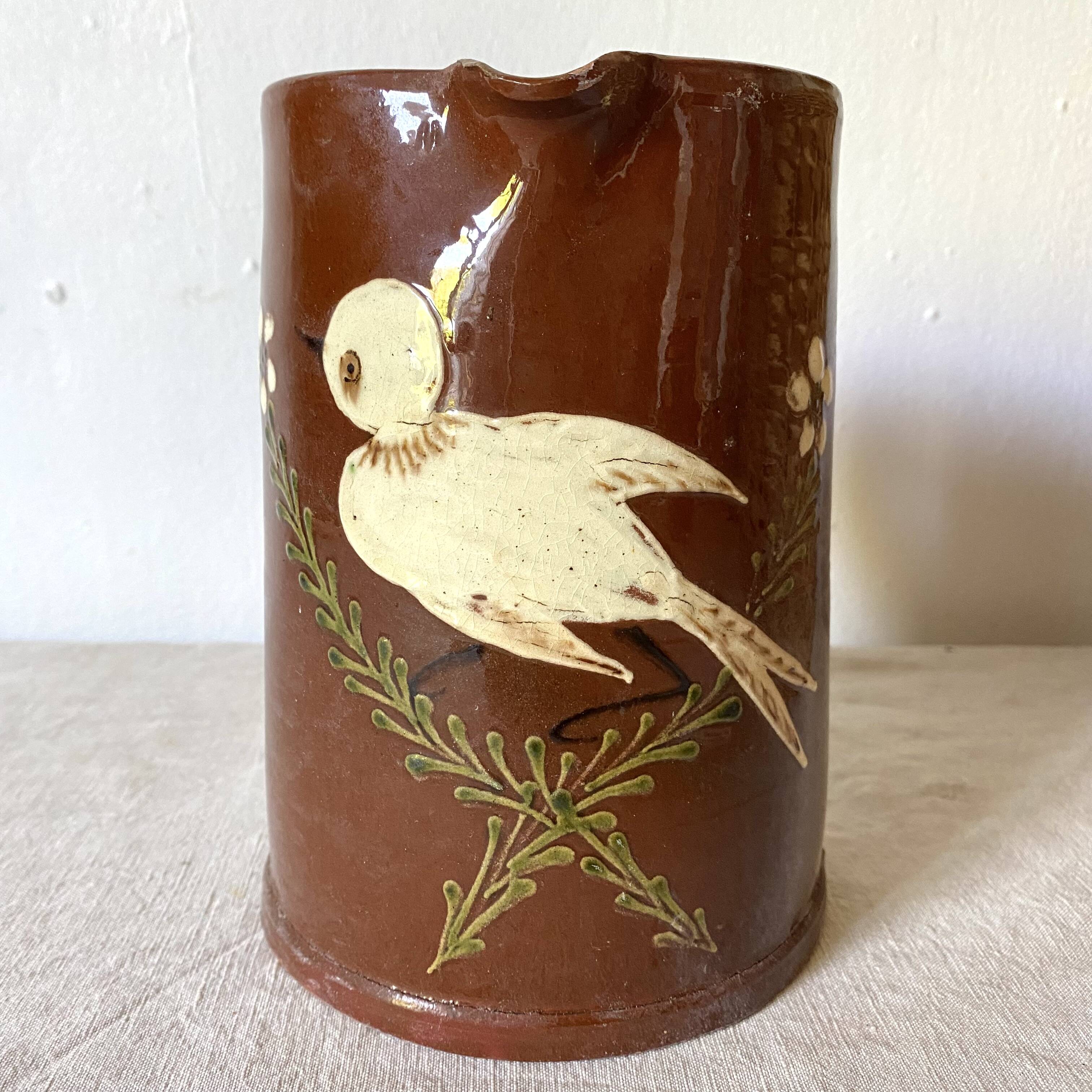 Terracotta pitcher with hand-painted bird decor