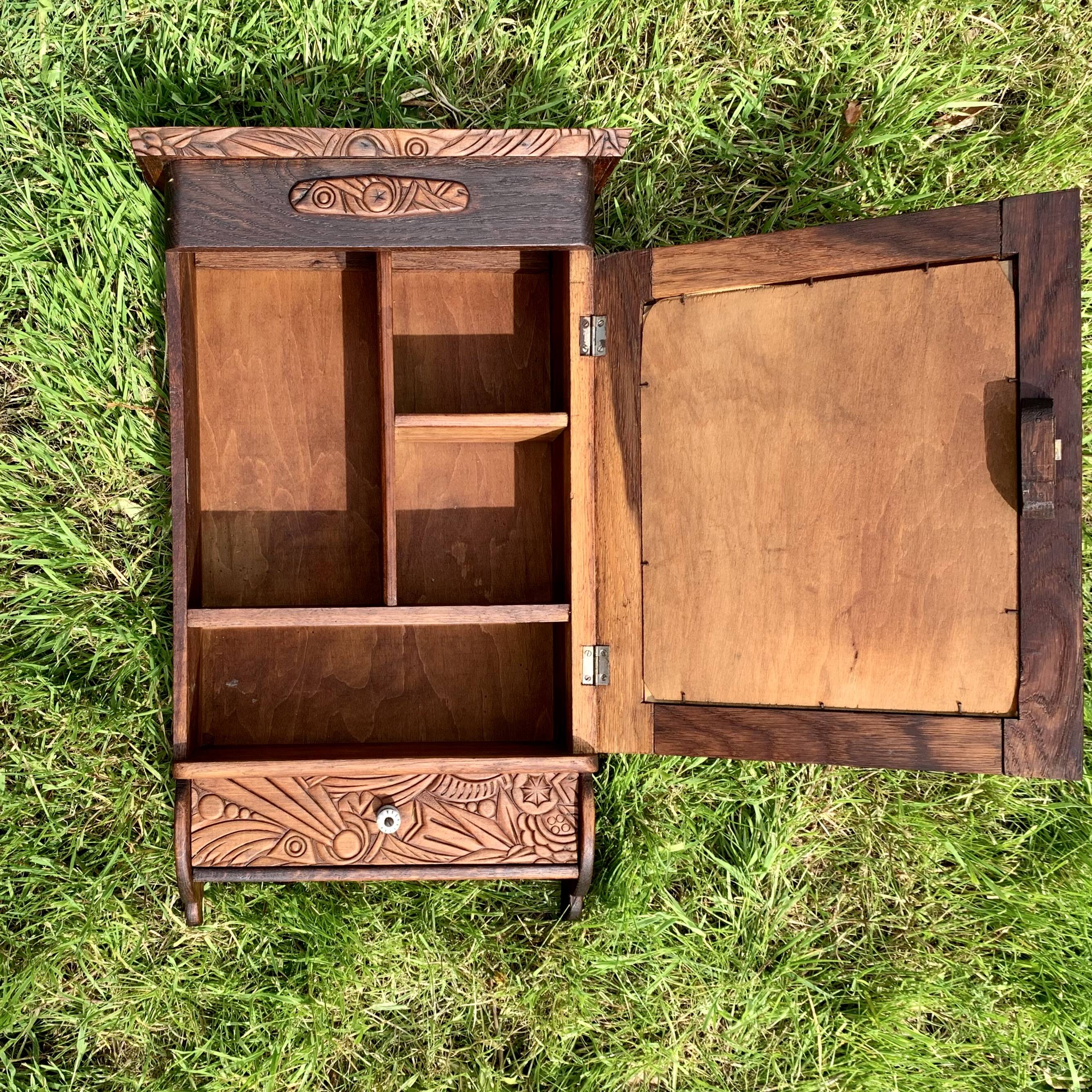Old carved wooden medicine cabinet with beveled mirror