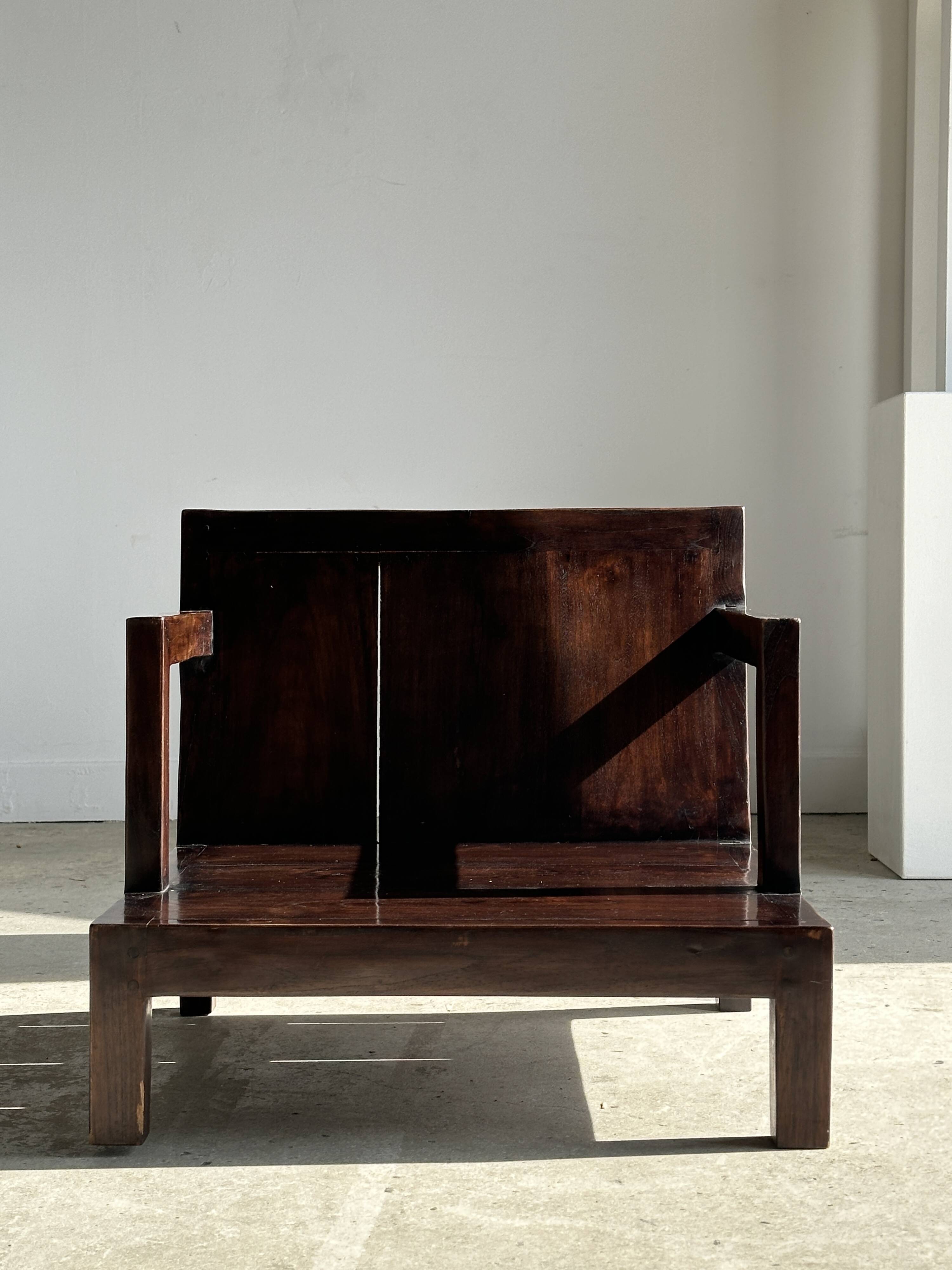 Small low armchair in varnished brown wood