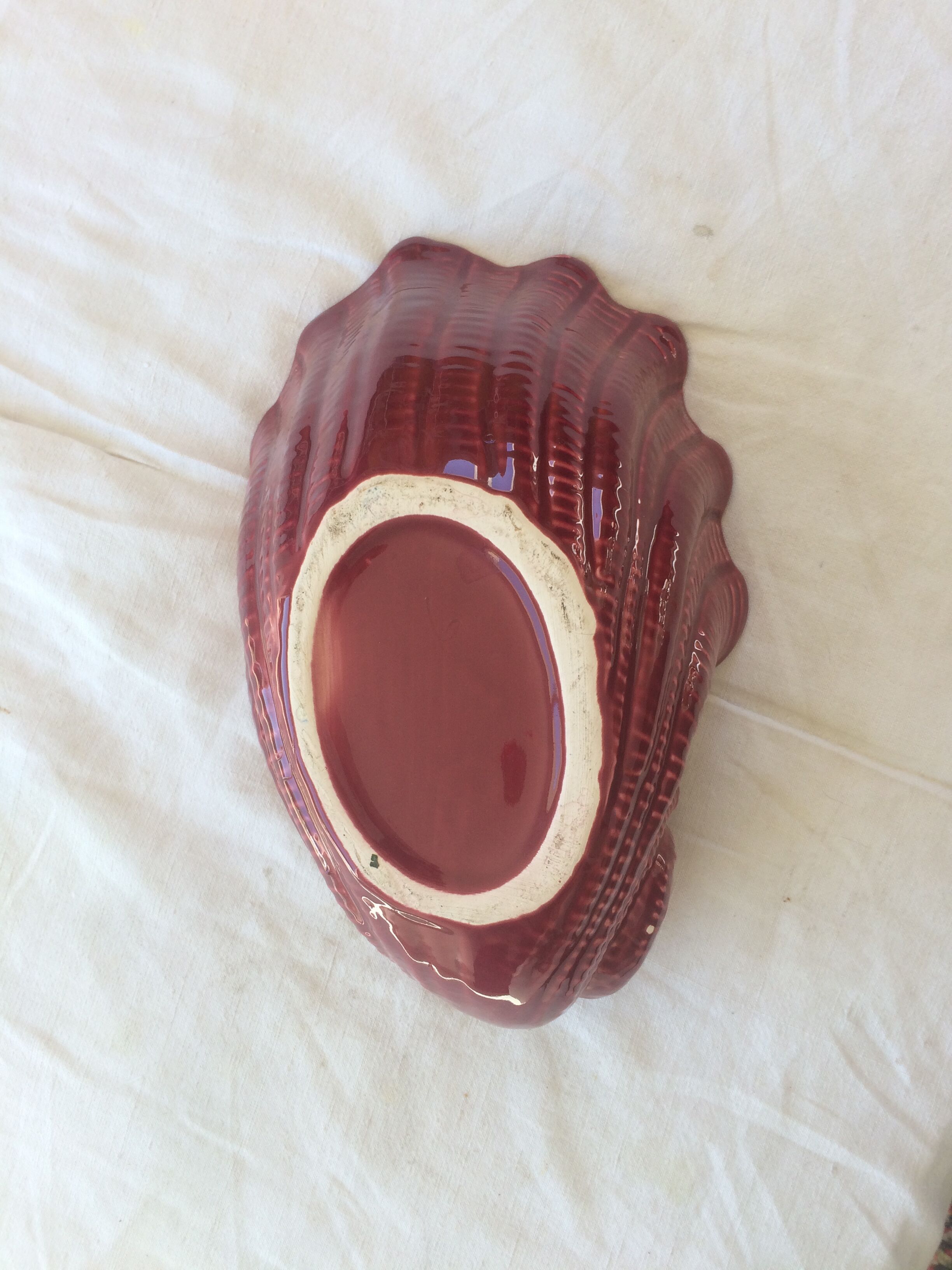 Empty red ceramic snail shaped pouch