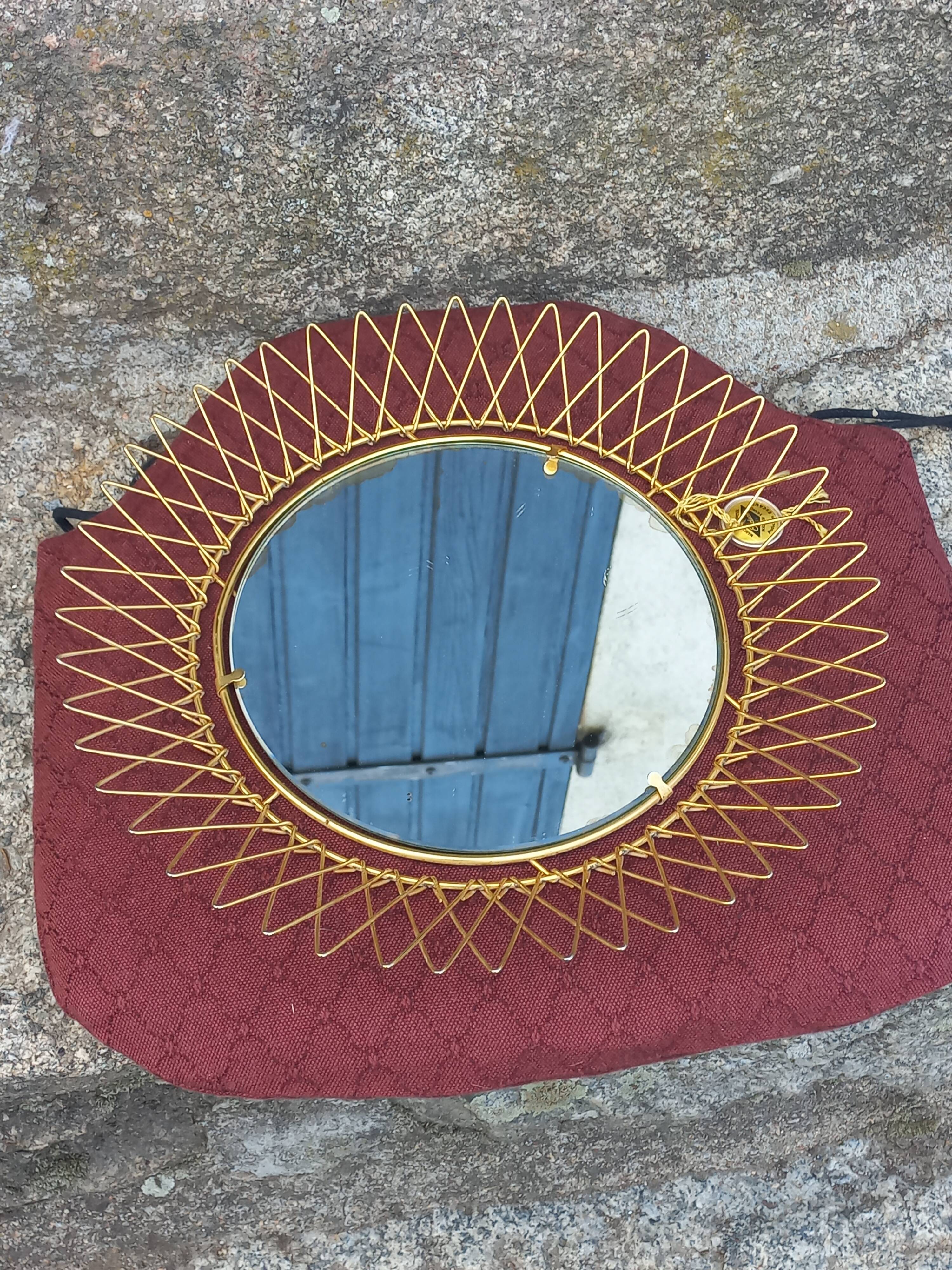 Vintage 1950s sun mirror in gold metal.