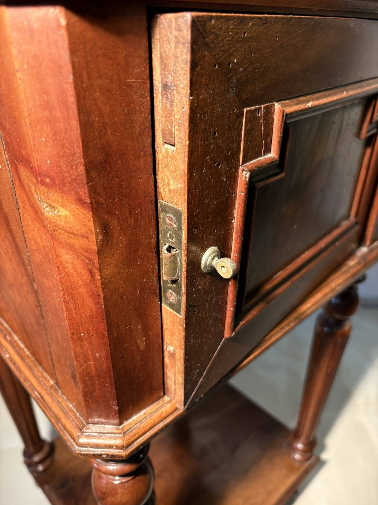 Antique wooden bedside table with turned legs.