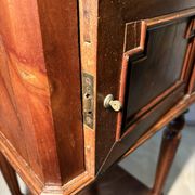 Antique wooden bedside table with turned legs.