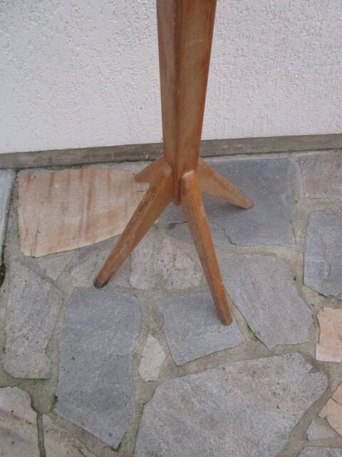 Antique light wood coat rack with splayed legs.