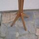 Antique light wood coat rack with splayed legs.